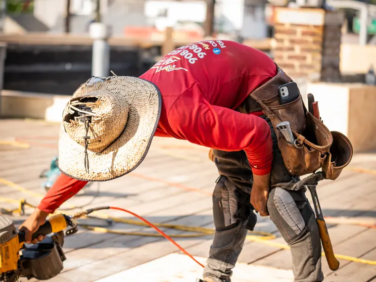 An A&J crew member nailing down decking on a flat roof