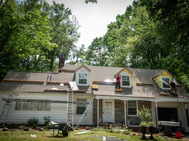 A New Jersey home with its roof stripped back to the bare deck and an A&J crew working across it